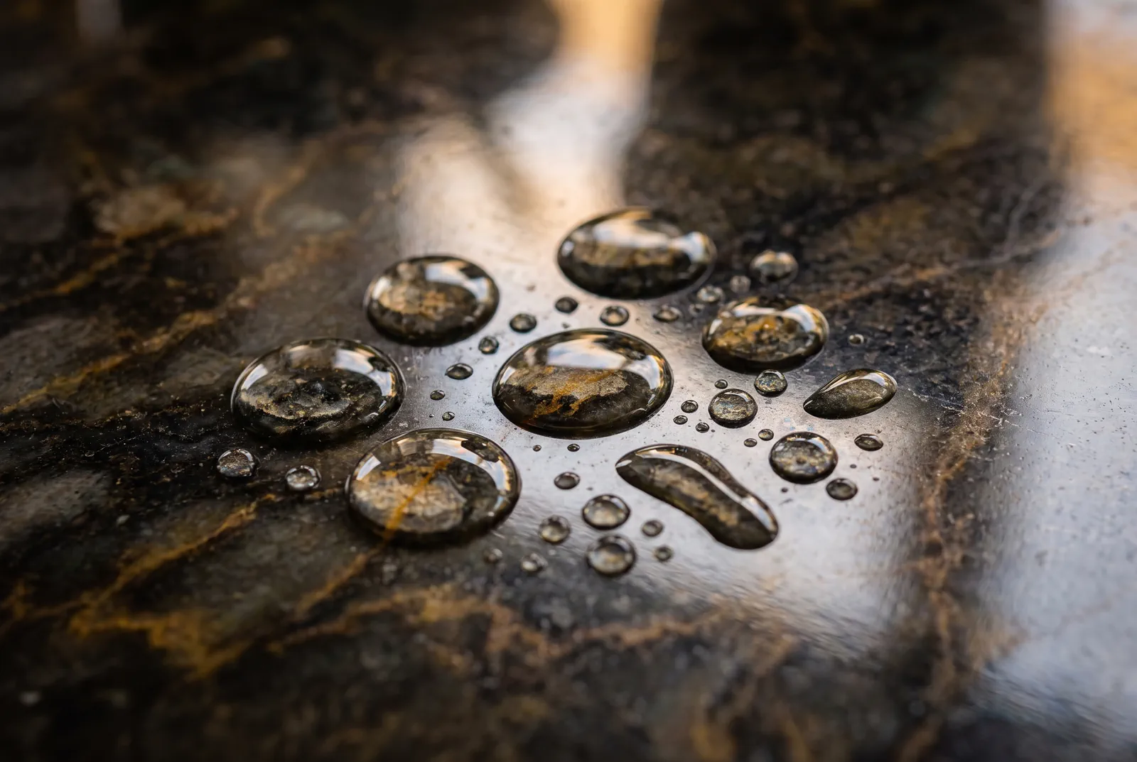 Professional stone sealing: water beading tightly on a sealed dark veined stone surface in Tampa Bay